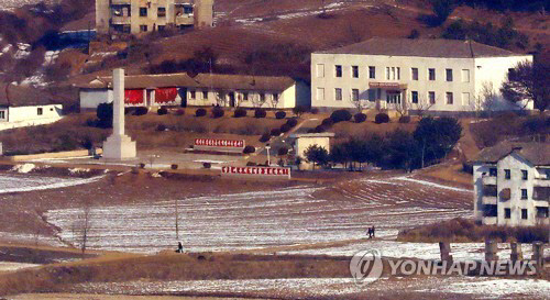북한이 무인기로 우리 영공을 침범해 남북 간 긴장이 고조되는 가운데 27일 오전 경기도 김포시 하성면 애기봉평화생태공원 조강전망대에서 바라본 북한 해물선전마을에서 주민들이 눈길을 걸어가고 있다.<연합뉴스>